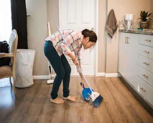 Tidy living room with someone doing light cleaning chores