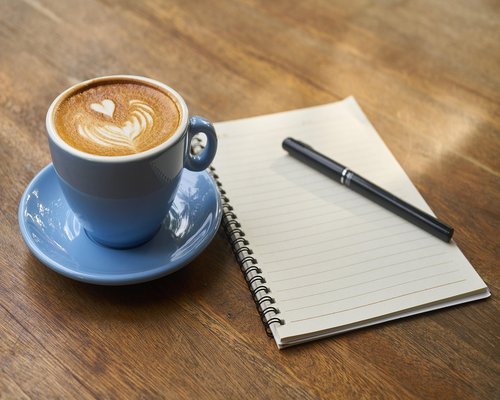 Editorial desk with notes and a cup of coffee